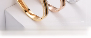 Detailed close-up of gold and rose gold titanium bracelets with sparkling pavé zircons