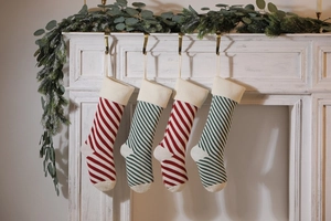 Close-up of knitted striped Christmas stockings hanging on a white fireplace mantle