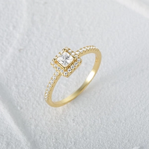 Macro shot of gold halo ring featuring a square princess cut diamond and pave band