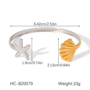 Detailed view of starfish and seashell charms on an open stainless steel cuff bracelet