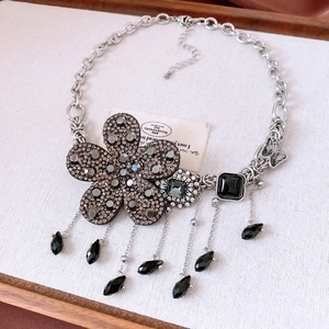 Détail du collier à fleurs vintage avec strass foncés et pendentifs à franges
