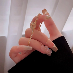 Detail view of gold-plated love knot bracelet with sparkling cubic zirconia inlay