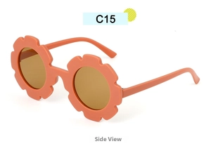 Side view of matte orange flower-shaped kids sunglasses with round dark lenses
