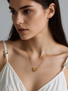 Close-up of a 18k gold plated necklace with a geometric zircon pendant on a model