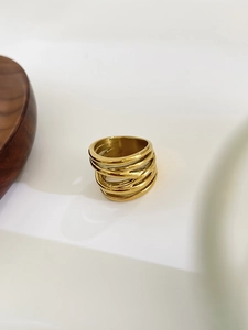 Detailed view of wide gold crisscross ring with polished multilayer winding design