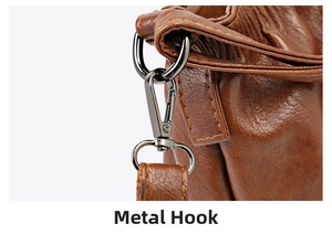 Detail of gunmetal spring hook on dark brown lychee leather bag with yellow stitching