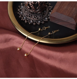 Detail of 18K gold S925 silver adjustable heart pendant and long chain earring texture