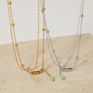 Double-layered stainless steel anklet with gold and silver chains featuring green beads