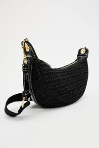 Detail of black woven crescent bag with leather trim and gold-toned metal hardware