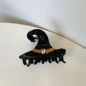 Detail of Halloween witch hat hair claw clip with black glitter finish and colorful gemstone