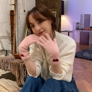 Pink knitted gloves featuring a red bow decoration, shown in a professional model shot