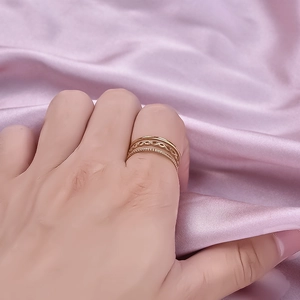 Minimalist triple-layered gold stainless steel rings shown on a model hand with satin background