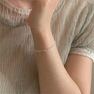 Close-up of minimalist S925 sterling silver geometric bracelet worn on a female wrist