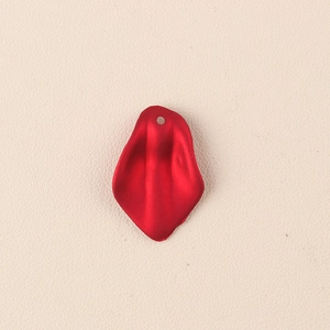 Dettaglio macro del ciondolo a petalo in acrilico rosso opaco con foro per gioielli DIY