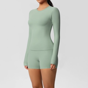 Detail of sage green long sleeve yoga top and high-waist shorts set in matte brushed fabric