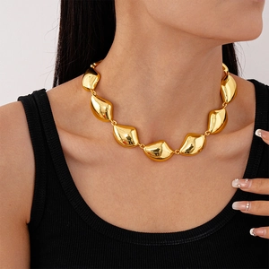 Dettaglio dei maglie dorate irregolari a forma di fagiolo sulla collana geometrica audace