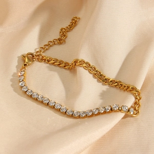 Macro shot of gold Cuban chain bracelet with cubic zirconia row on champagne silk