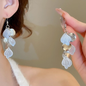 Detail of silver long tassel earrings with light blue translucent resin shell leaves