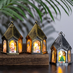 Three vintage Christmas LED lanterns with Santa and Snowman on a wooden surface