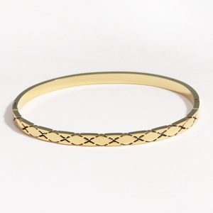 Vue macro détaillée du bracelet en acier inoxydable doré avec texture à motif losange
