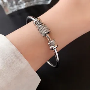 Elegant silver open bangle with pavé zircon cylinder and polished knot detail for women