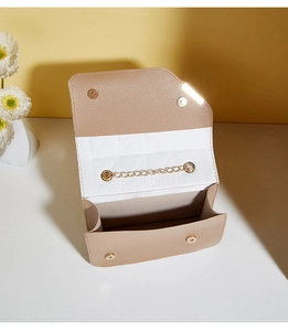 Detail view of champagne gold crossbody bag with magnetic buckle and golden chain