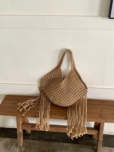 Borsa a tracolla con frange in macramè bohémien fatta a mano, dettaglio stile vacanza mare.