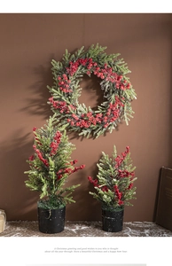 Detailed view of Christmas wreath and potted mini trees with red berries and snow dust