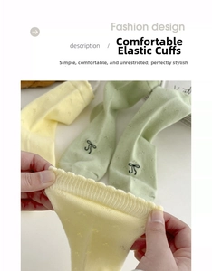 Detail of cream socks with breathable hollow mesh, ruffled cuffs, and bow embroidery