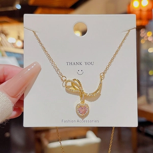 Pink heart pendant necklace with gold bow knot and sparkling cubic zirconia crystals