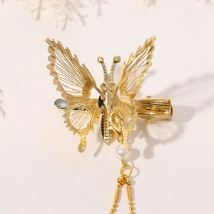 Exquisite golden butterfly hair clip with delicate pearl chain tassels and metal wings