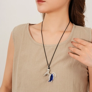 Détail du long collier en cordon ciré avec pendentif cheval argenté et perles bleues