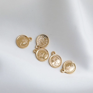 Makro-Detail von 14K vergoldeten Münzanhängern mit Porträt von Königin Elisabeth II