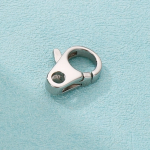 Detailed close-up of a polished silver stainless steel lobster clasp on light blue paper