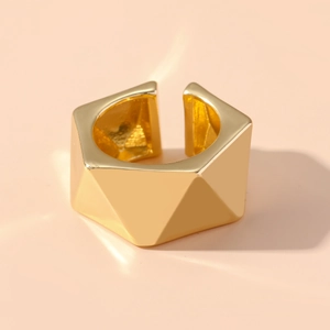 Detail shot showing the geometric faceted texture on a gold wide band adjustable ring