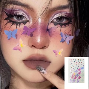 Detail of gradient butterfly face stickers with rhinestones on model's cheek and nose