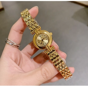 Detail of small gold dial with Roman numerals and quartz movement on vintage watch