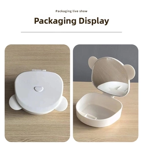 Detail view of the open bear-shaped makeup box with an integrated folding mirror
