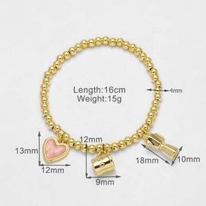 Detalle de pulsera bañada en oro de 18k con corazón de esmalte rosa y dijes grabados
