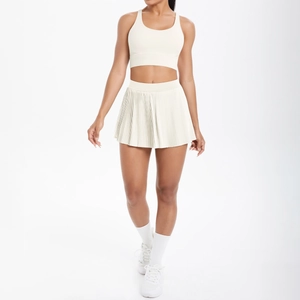 Détail de l'ensemble de tennis blanc cassé avec jupe plissée taille haute et gilet