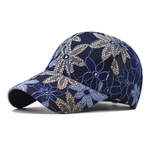 Close-up of navy blue mesh baseball cap with intricate light blue lace floral embroidery