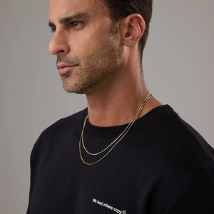 Detail of layered gold and silver snake chains on neck for a minimalist fashion style