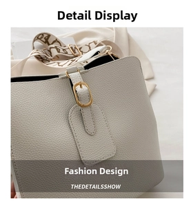 Detail of lychee pattern leather bucket bag with gold buckle and printed wide strap