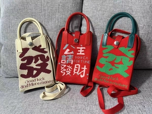 Detail of knitted phone bags with good luck slogans and money-themed embroidery