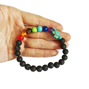 Matte black volcanic stone bracelet with colorful energy beads and a green turtle charm