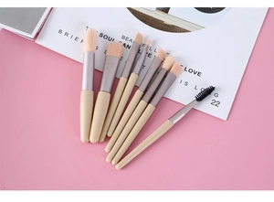 Close-up of 8-piece makeup brush set with matte yellow handles and soft pink bristles