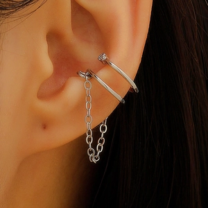 Nahaufnahme einer silbernen Doppel-Ohrmanschette mit Kette und strukturiertem Metalldetail