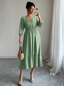 Robe longue verte élégante à pois avec col en V, boutons et ourlet à volants fluide