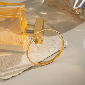 Elegant gold snake cuff bracelet with detailed scales and minimalist open design