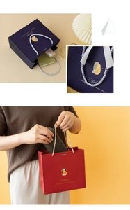 Close-up of premium teacher gift bags with braided handles and artistic illustrations